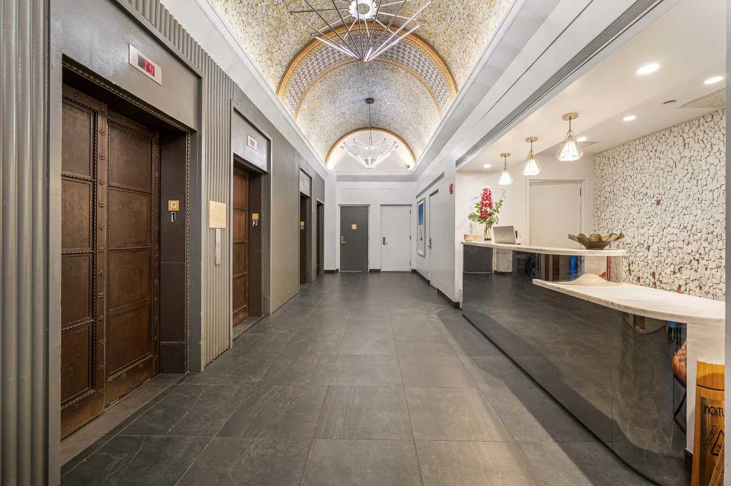 A hallway with a marble counter and a decorative ceiling.